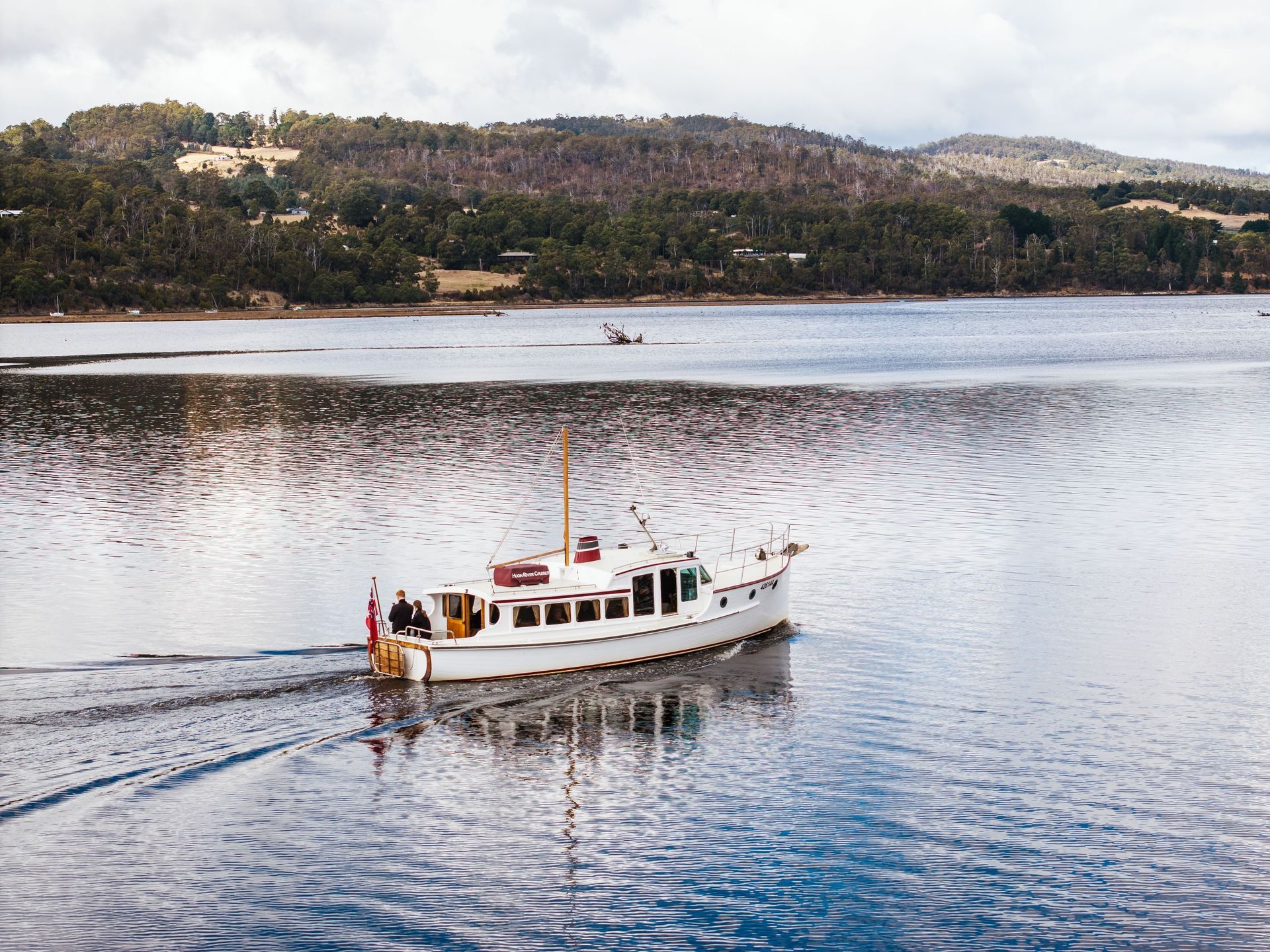 A white boat is floating on top of a body of water