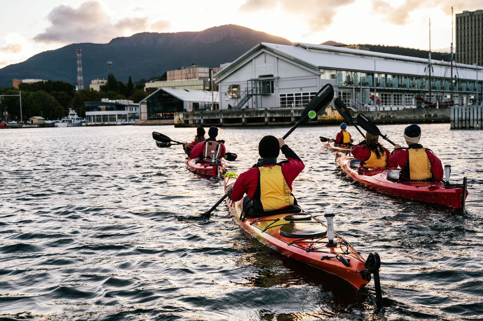 A group of people are paddling kayaks on a lake.