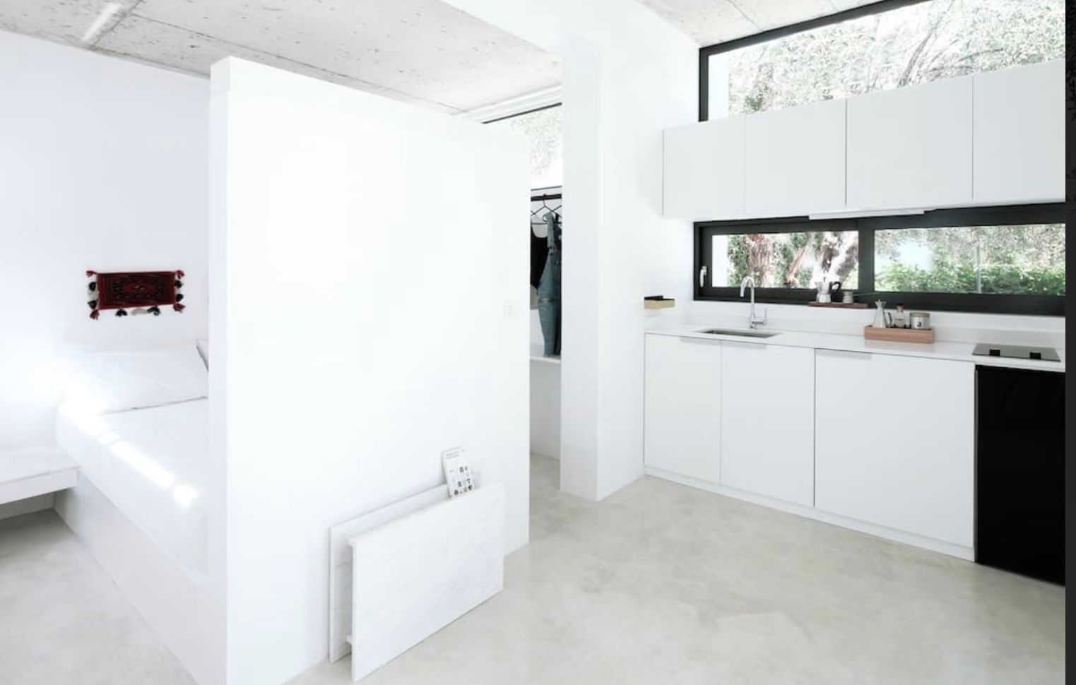A kitchen with white cabinets and a black dishwasher