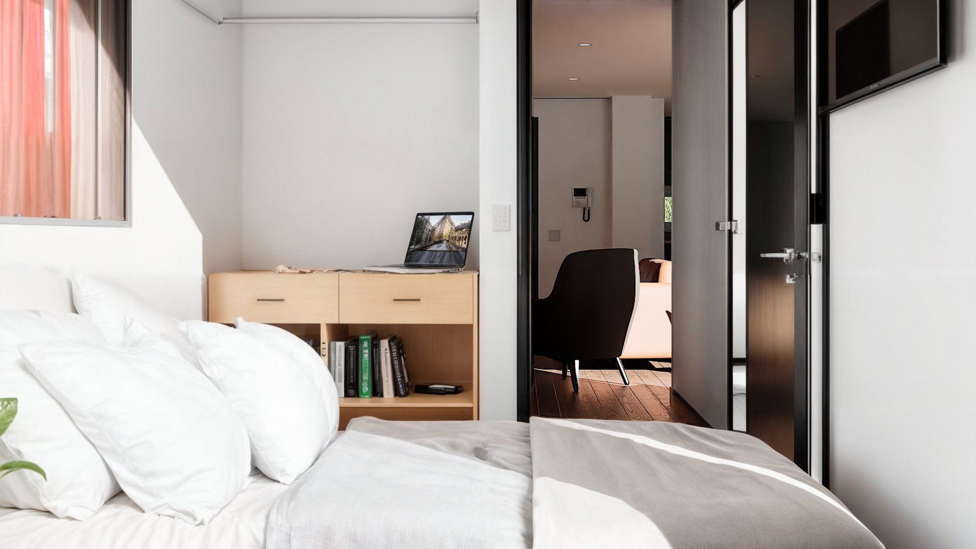 A bedroom with a bed and a desk with a laptop on it.