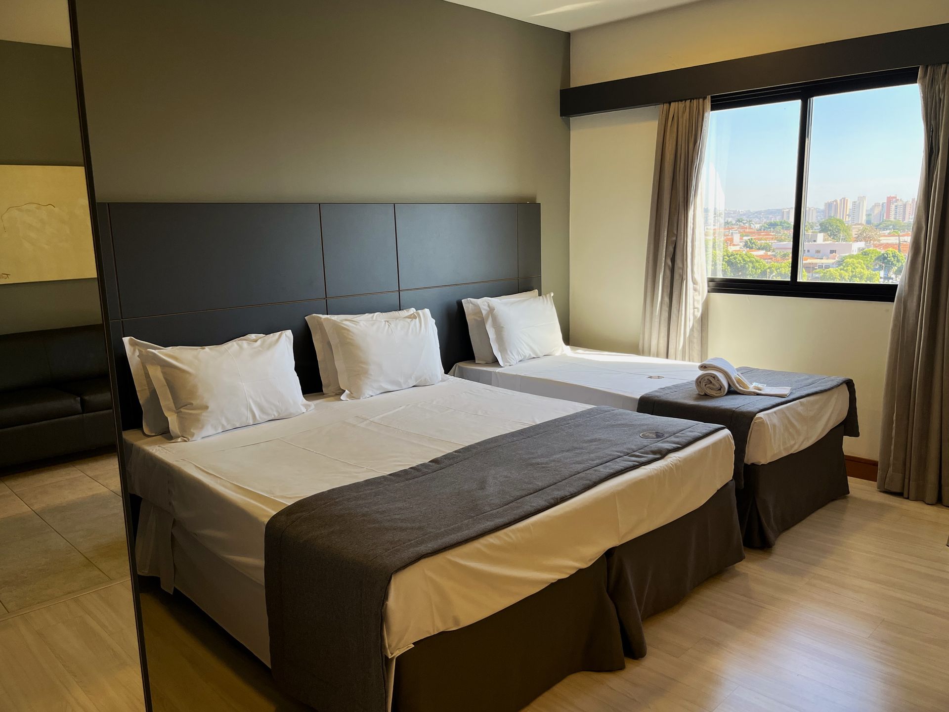 Um quarto de Hotel com uma cama queen size e uma cama de solteiro.