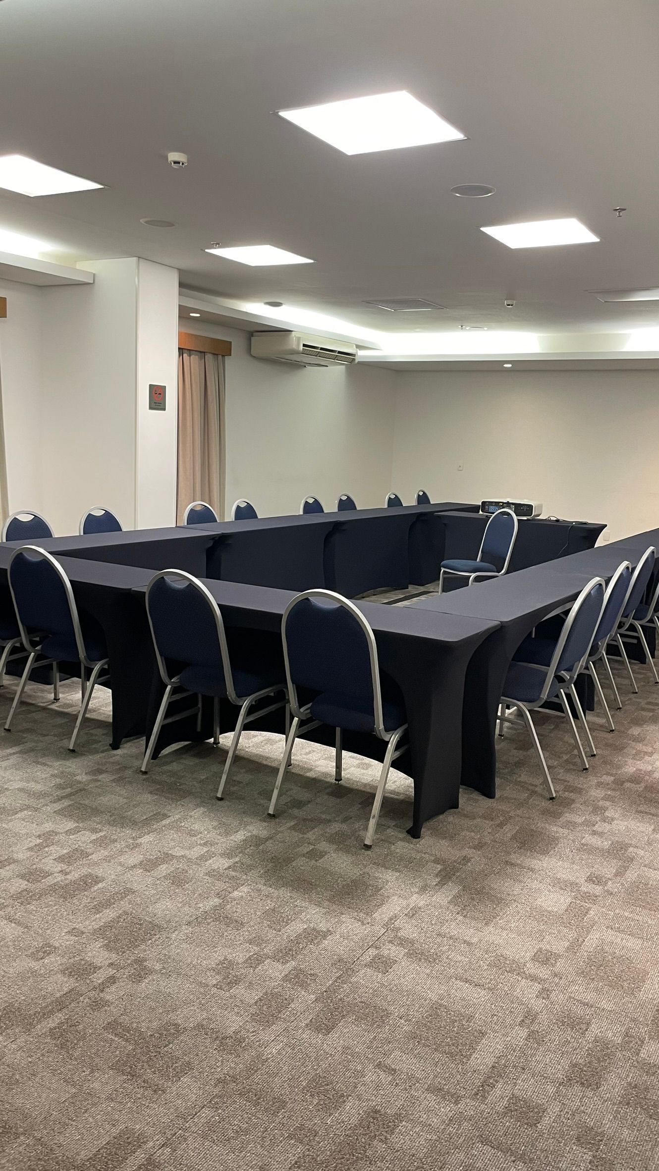 Há muitas mesas e cadeiras na sala.