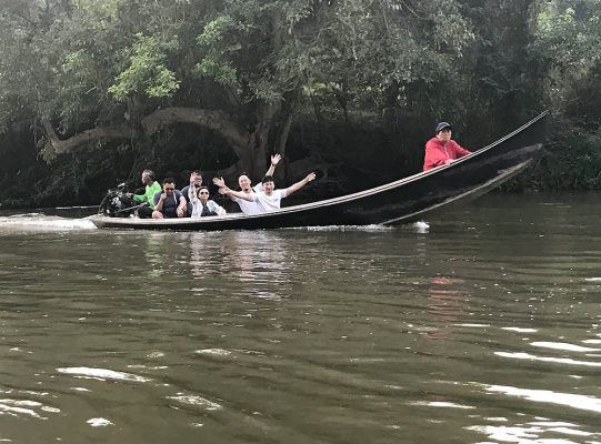 A group of people are riding in a boat on a river.