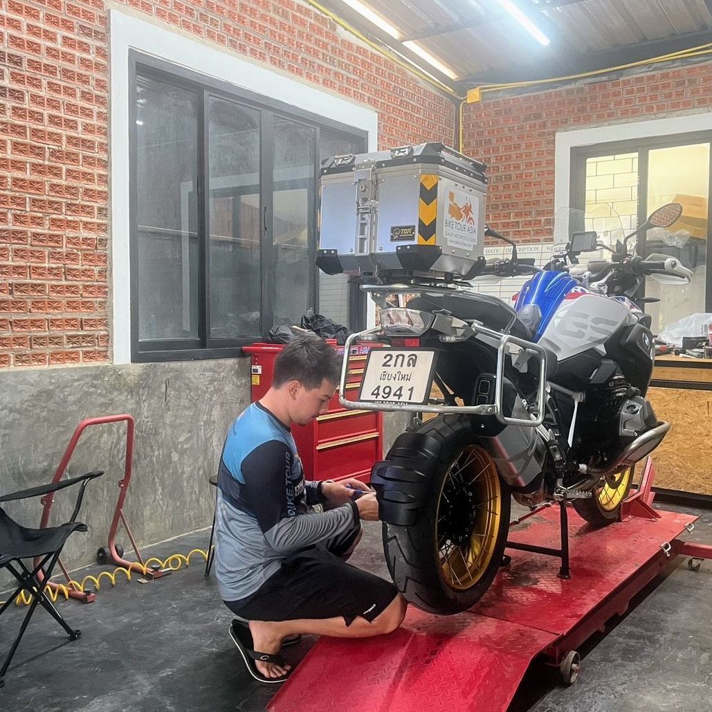 A man is working on a motorcycle in a garage.