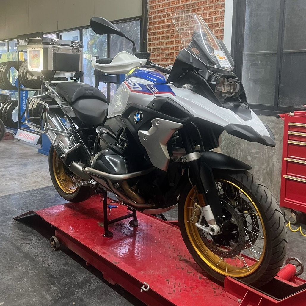 A motorcycle is sitting on a red ramp in a garage.