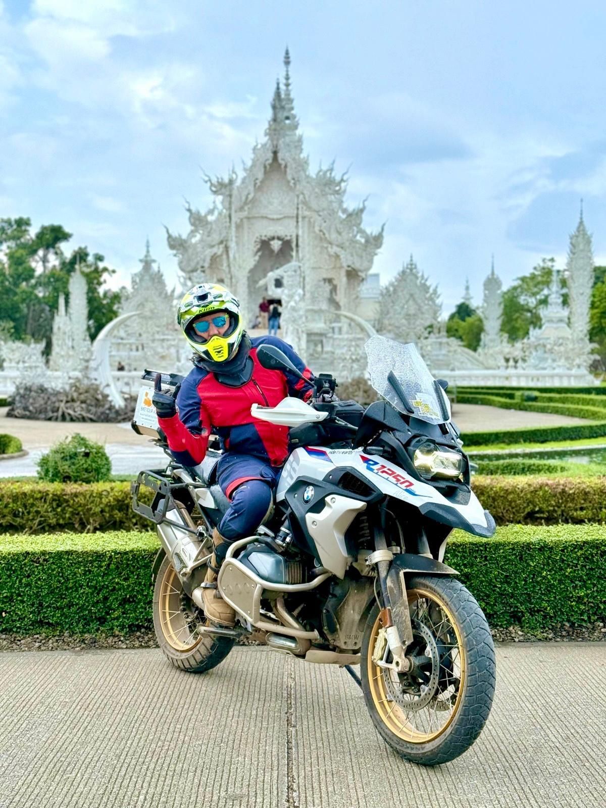 Bike Tour Asia rider in front of Chiang Rai white temple, Wat Rong Khun