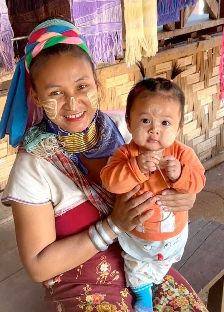 Karen village mother holding her child during a cultural visit in Northern Thailand