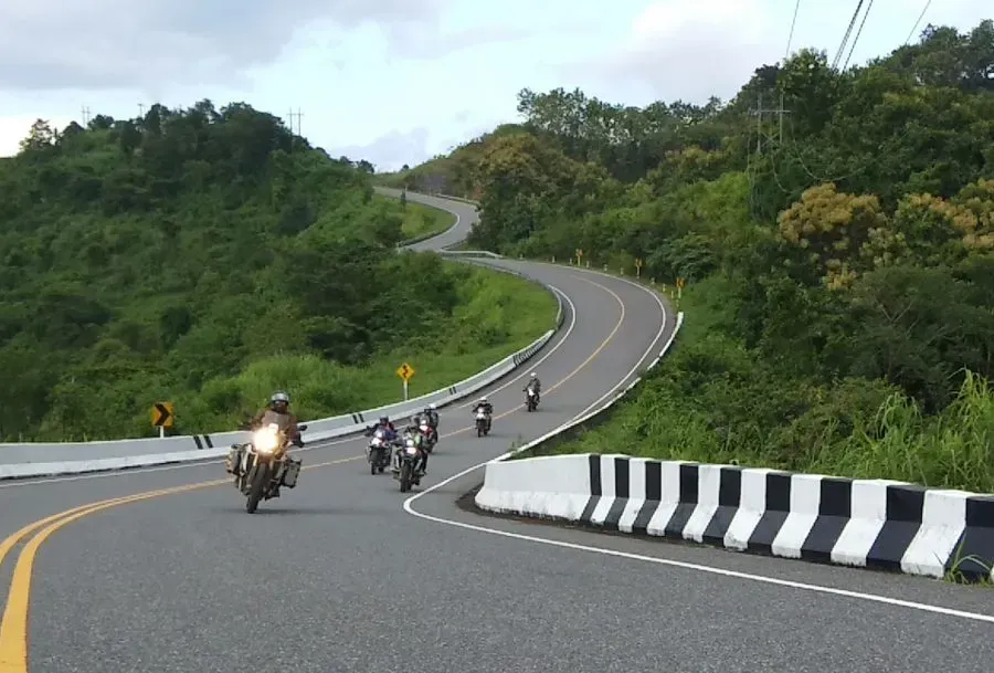 Group of riders leaning into mountain curves on Route 1081 in Nan, northern Thailand