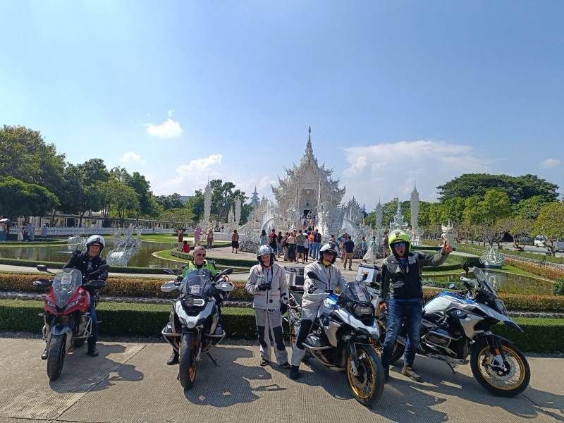 Bike Tour Asia riders with motorcycles in front of the White Temple (Wat Rong Khun) in Chiang Rai, Thailand