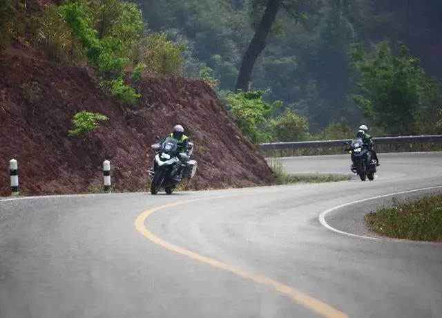 Motorcyclists leaning into scenic mountain curves in northern Vietnam