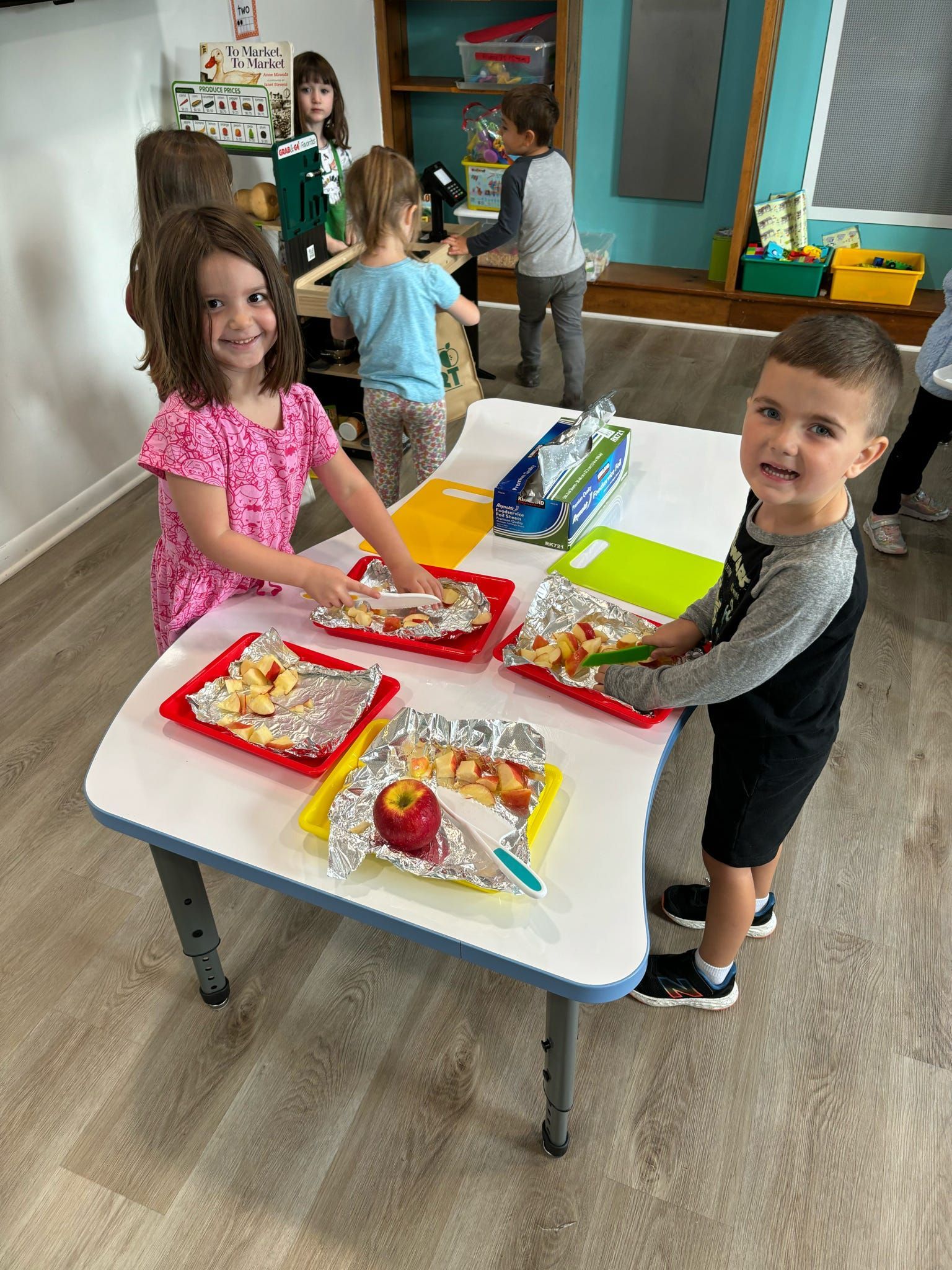 A group of children are sitting at a table with plates of food.