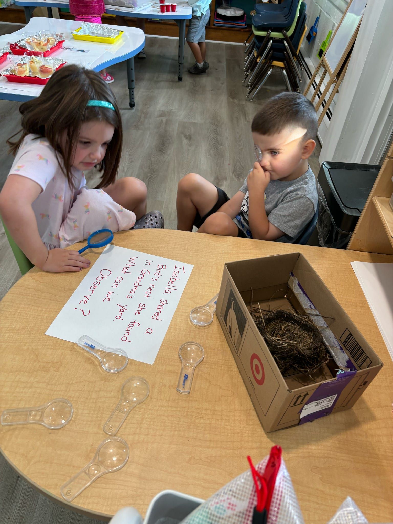 A boy and a girl are sitting at a table in a classroom.