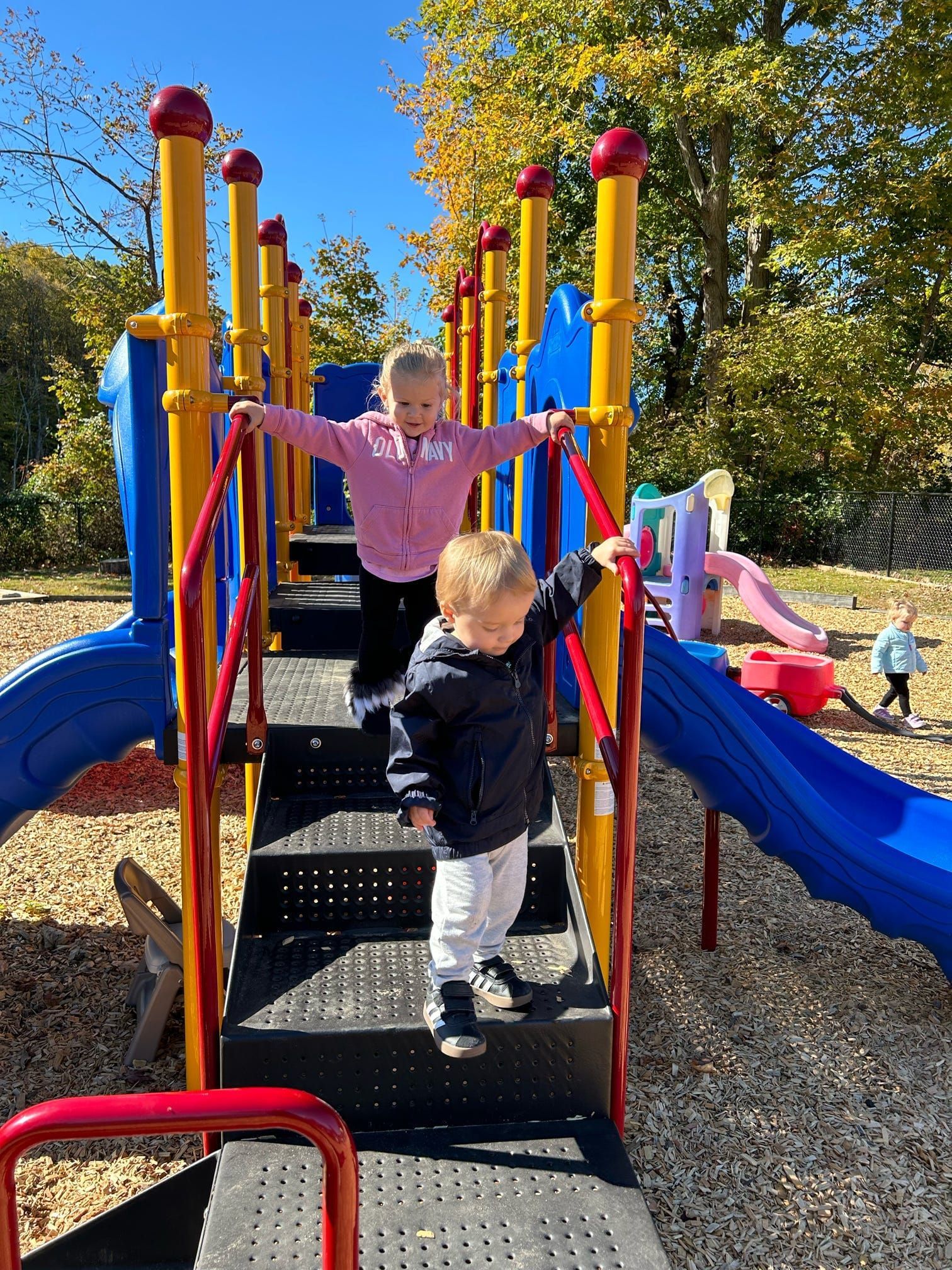 Two young children are playing on a playground.