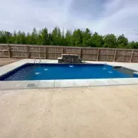 inground pool with waterfall