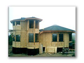 Two-story unfinished house with beige walls and dark roof