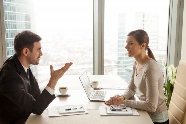 Empresario y empresaria conversando en el trabajo Empresario y empresaria conversando en el trabajo