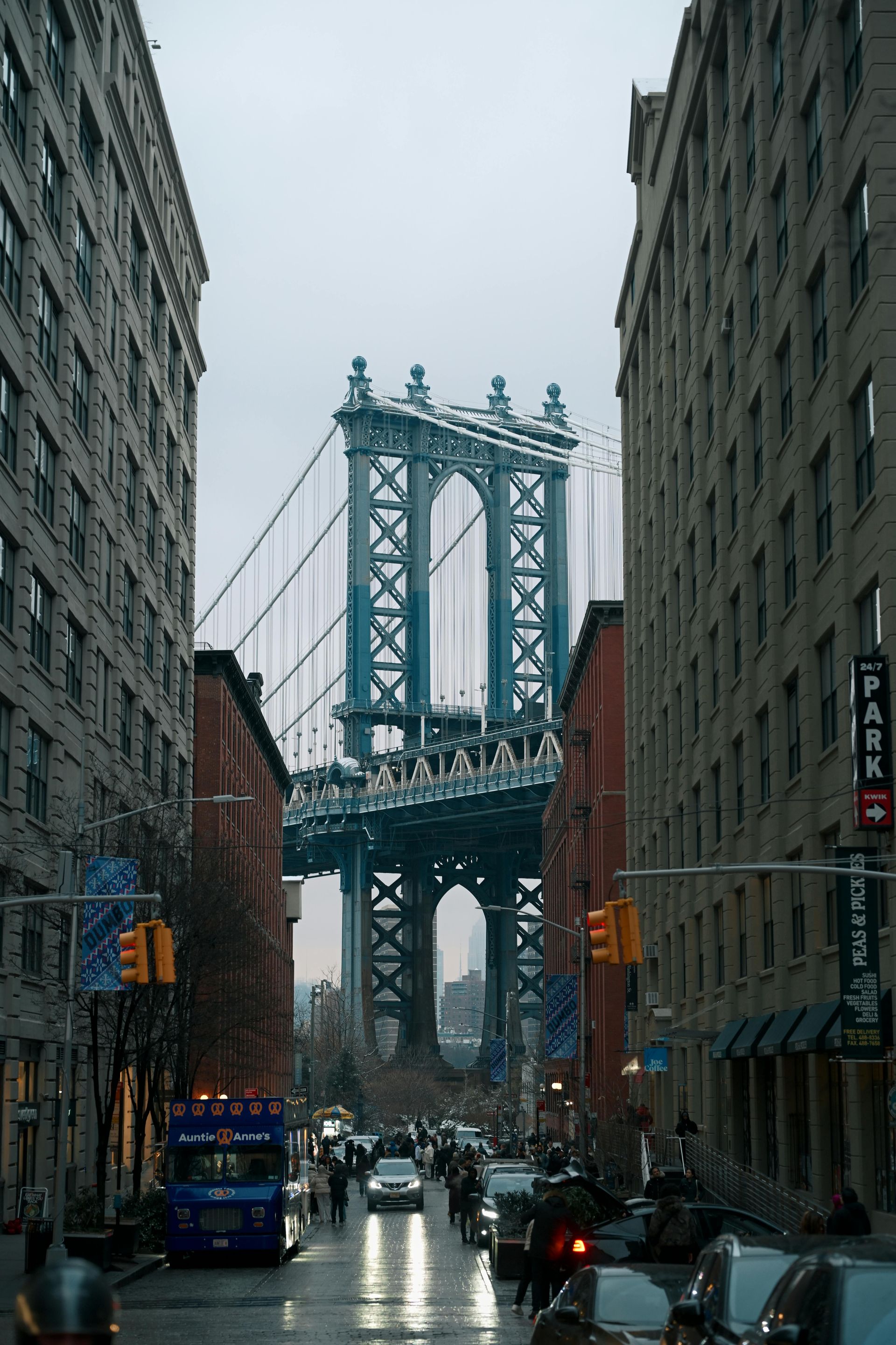 Rainy street leading to the Manhattan Bridge between tall buildings in New York City