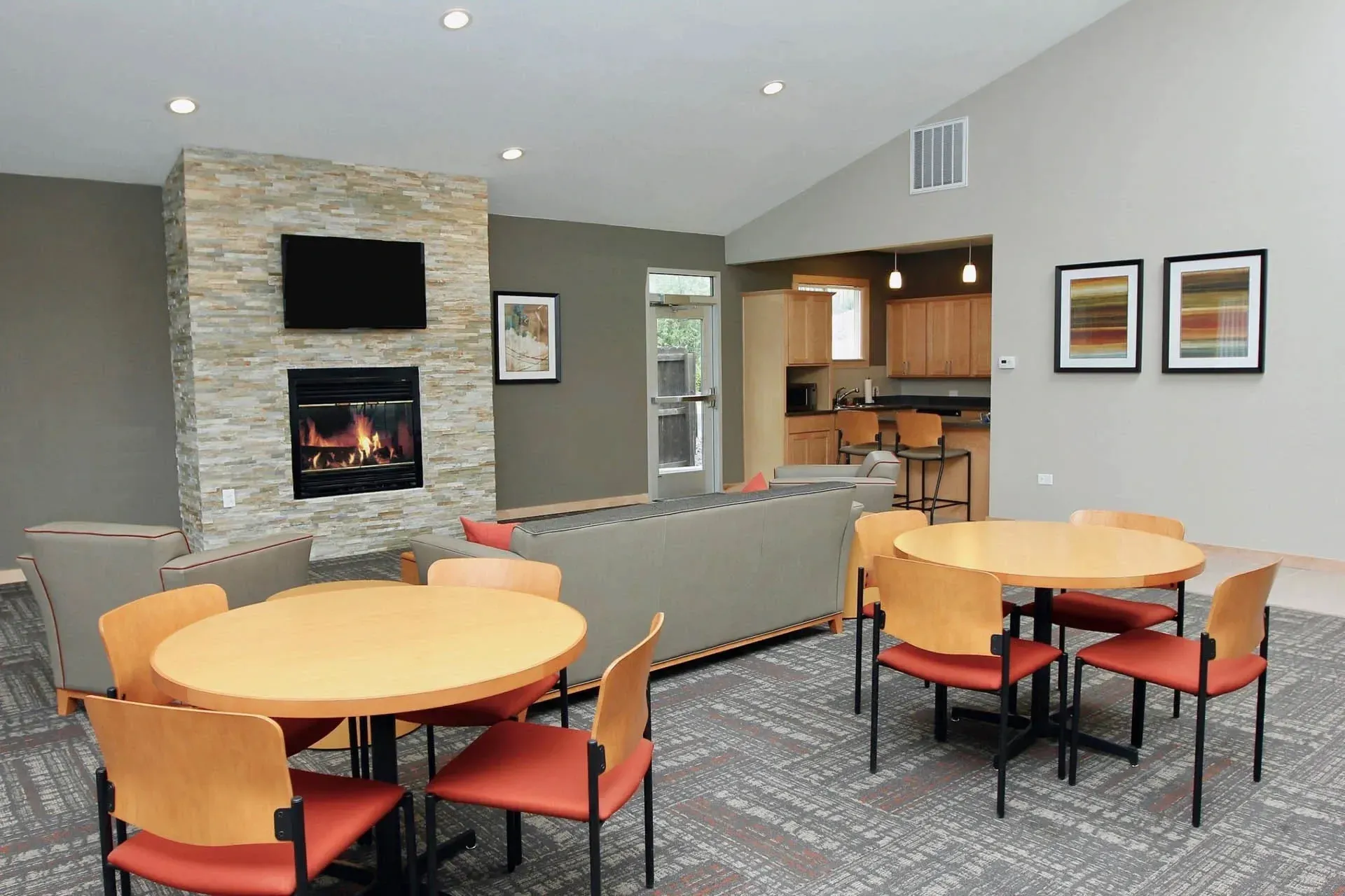 Thumbnail 4 of 51 - A stone fireplace is in the corner of a room with a table and chairs.