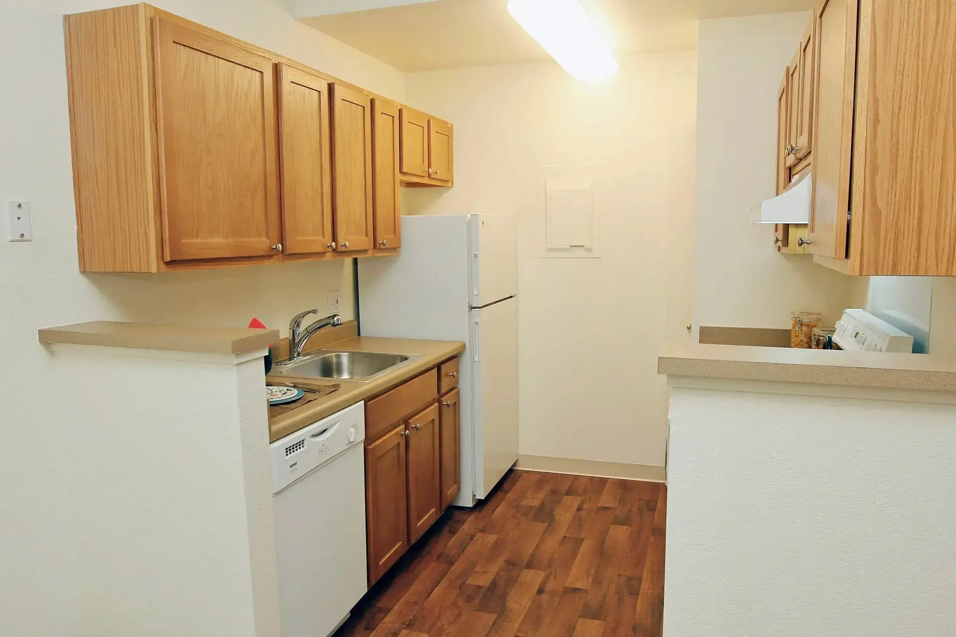 Thumbnail 14 of 51 - A kitchen with wooden cabinets and white appliances.