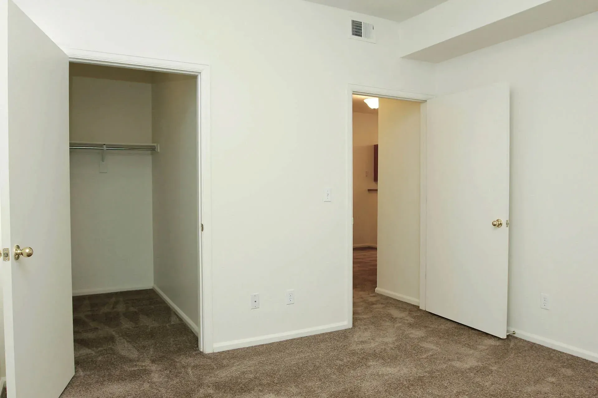 Thumbnail 26 of 51 - A room with carpeted flooring and two open doors.