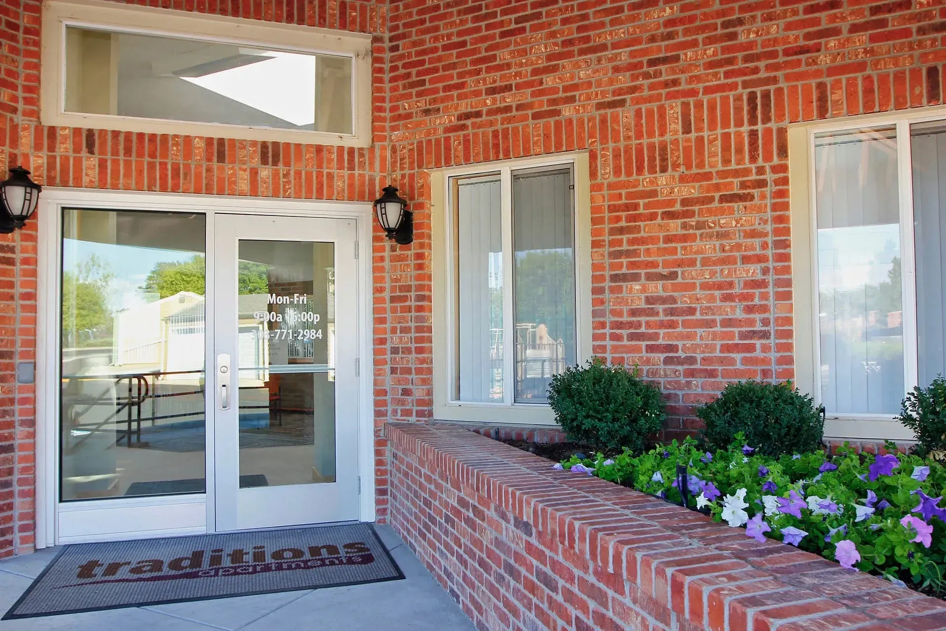 Thumbnail 36 of 51 - A red brick building with a glass door and window.