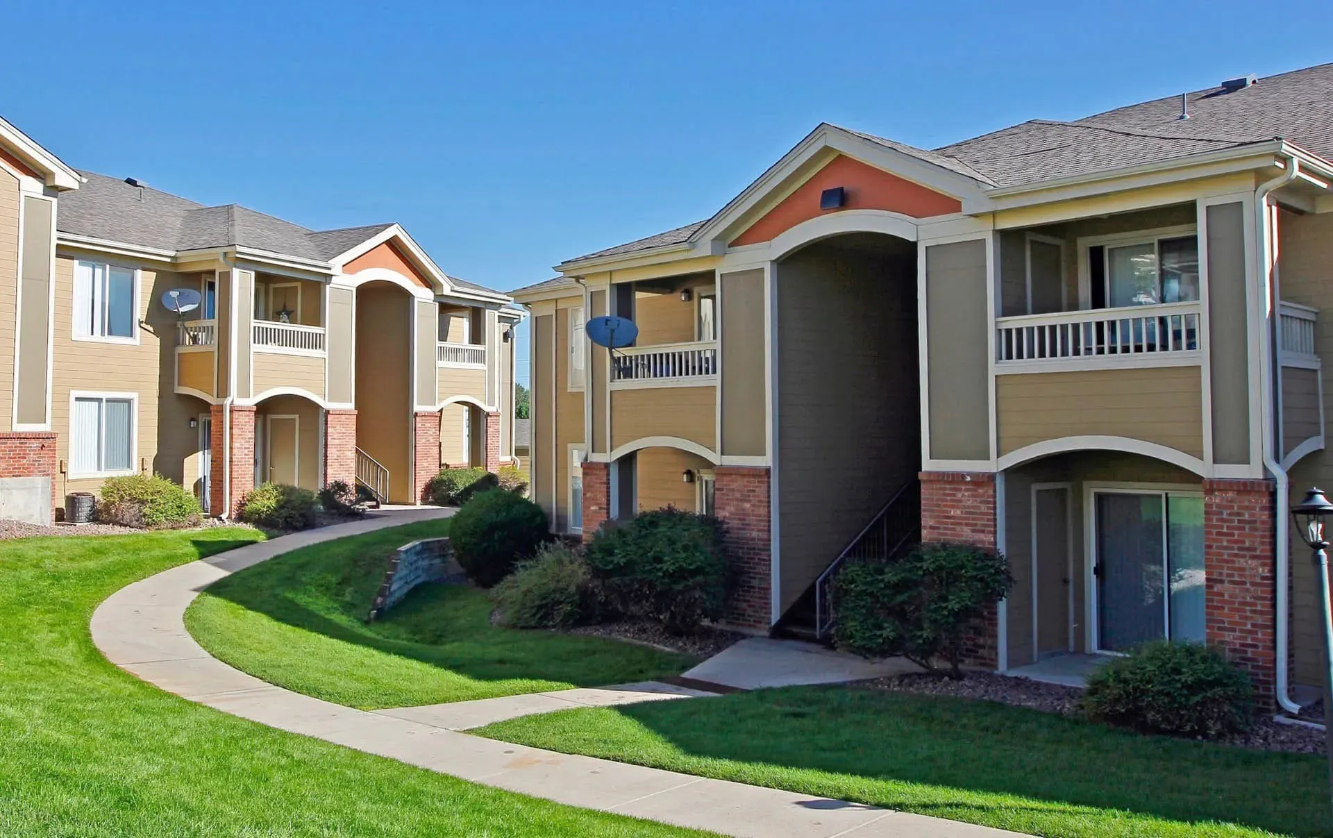 Thumbnail 39 of 51 - Apartment buildings with a green lawn in front.