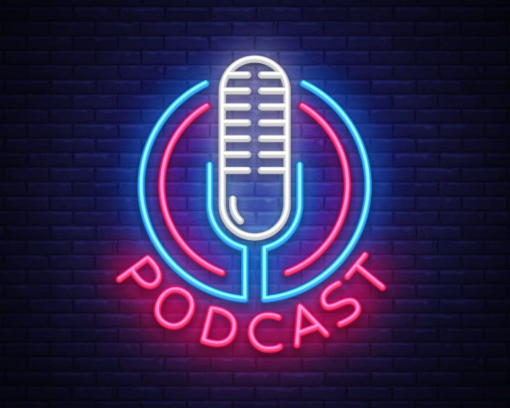 Neon sign: microphone within blue and pink circle, text