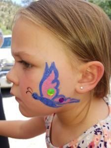 A little girl with a butterfly painted on her face.
