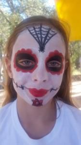 A young girl with a spider web painted on her face.