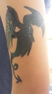 A person has a tattoo of a dragon on their arm.