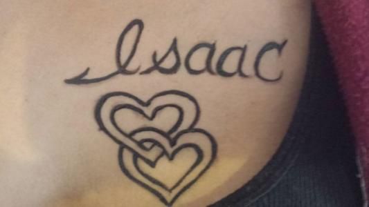A woman has a tattoo of the name isaac and three hearts