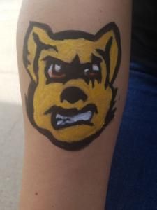 A person has a tattoo of a yellow dog on their arm