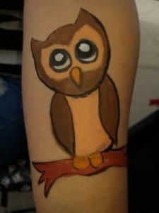 A person has an owl painted on their arm