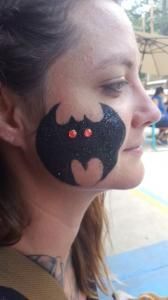 A woman with a bat painted on her face.