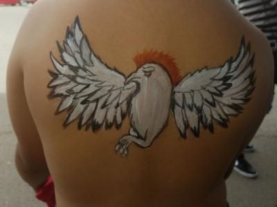 A person has a tattoo of a bird on their back