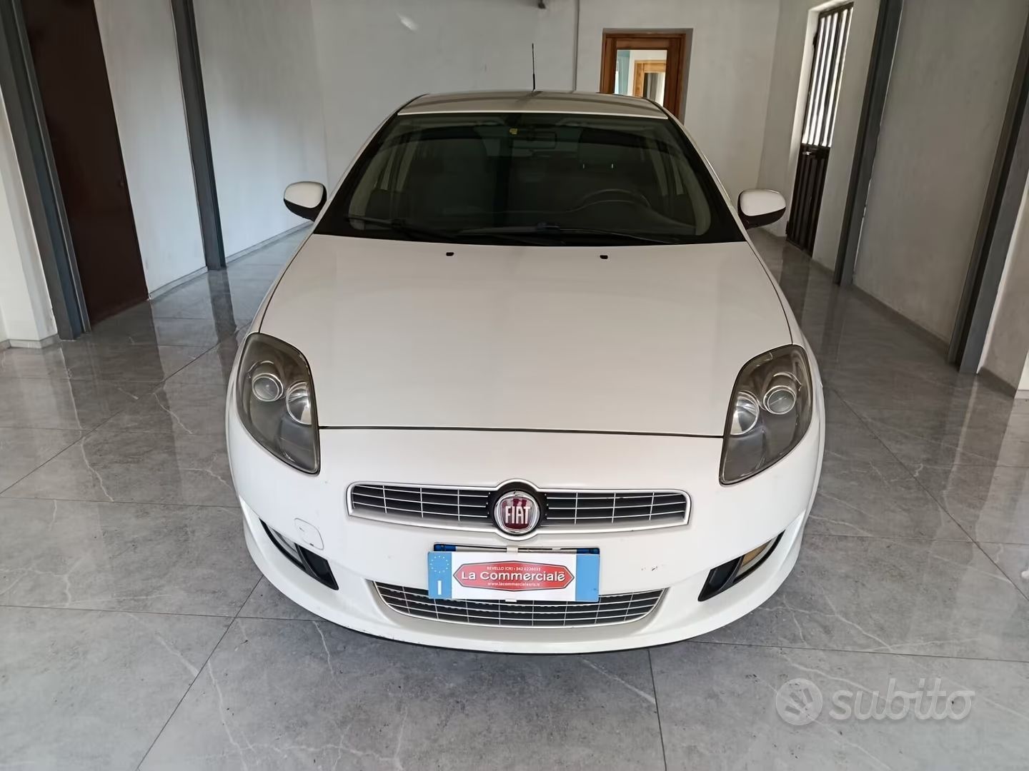 Berlina Fiat bianca parcheggiata in un garage, vista frontale