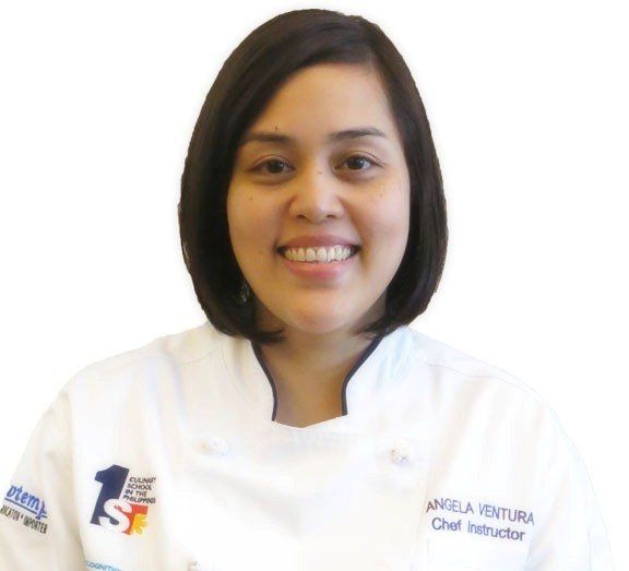 Smiling chef in a white uniform against a plain white background