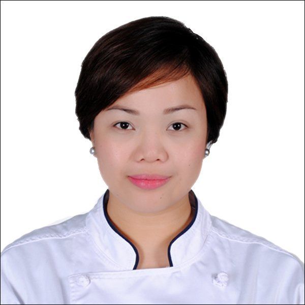 Portrait of a person in a white chef jacket on a plain white background