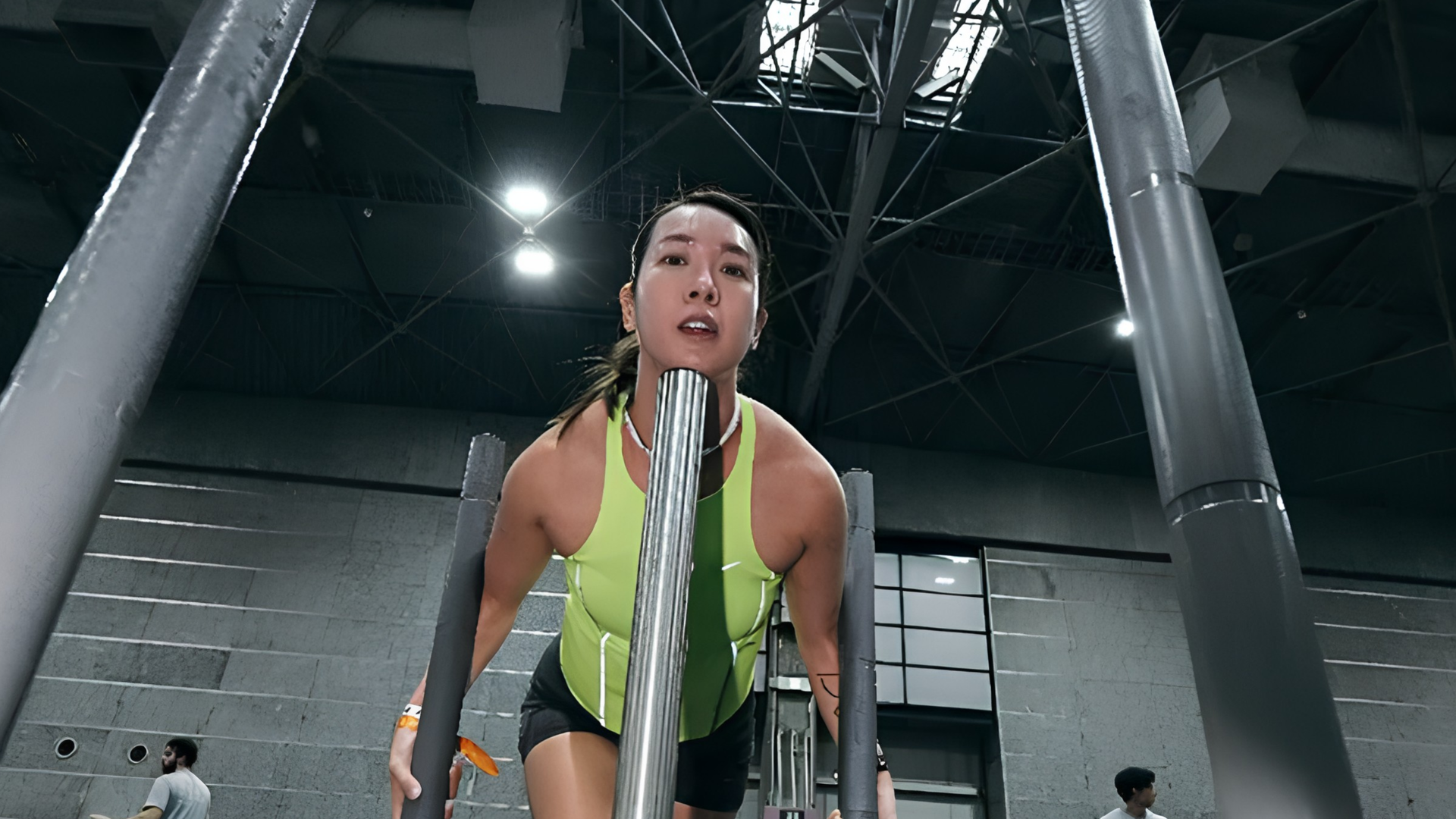 Person exercising, pushing weighted plates on a sled in a HYROX competition
