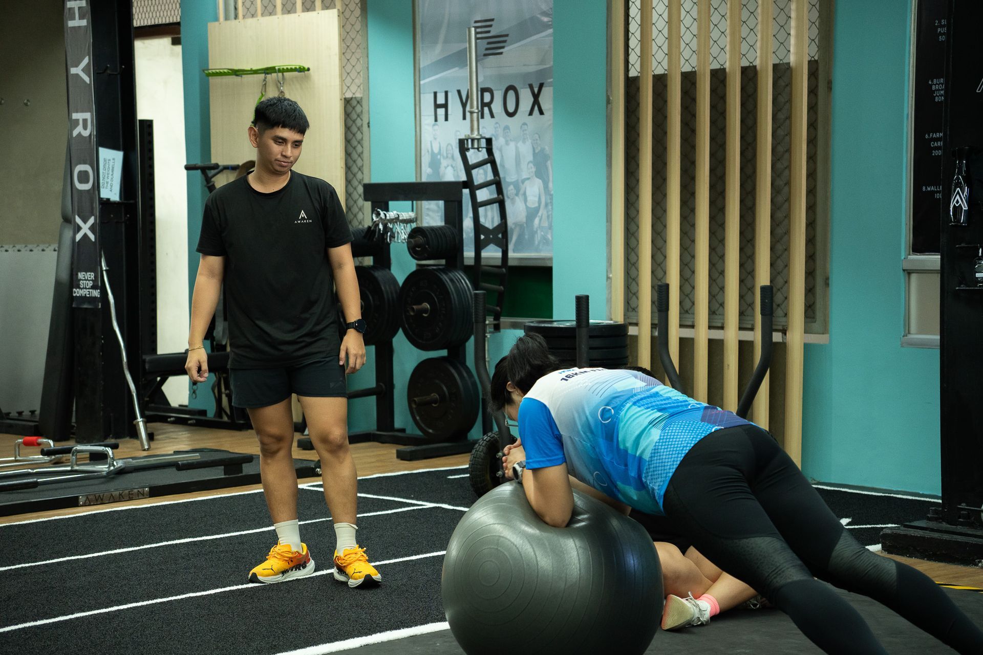 A group of people practicing a seated spinal twist yoga pose on mats in an indoor studio.