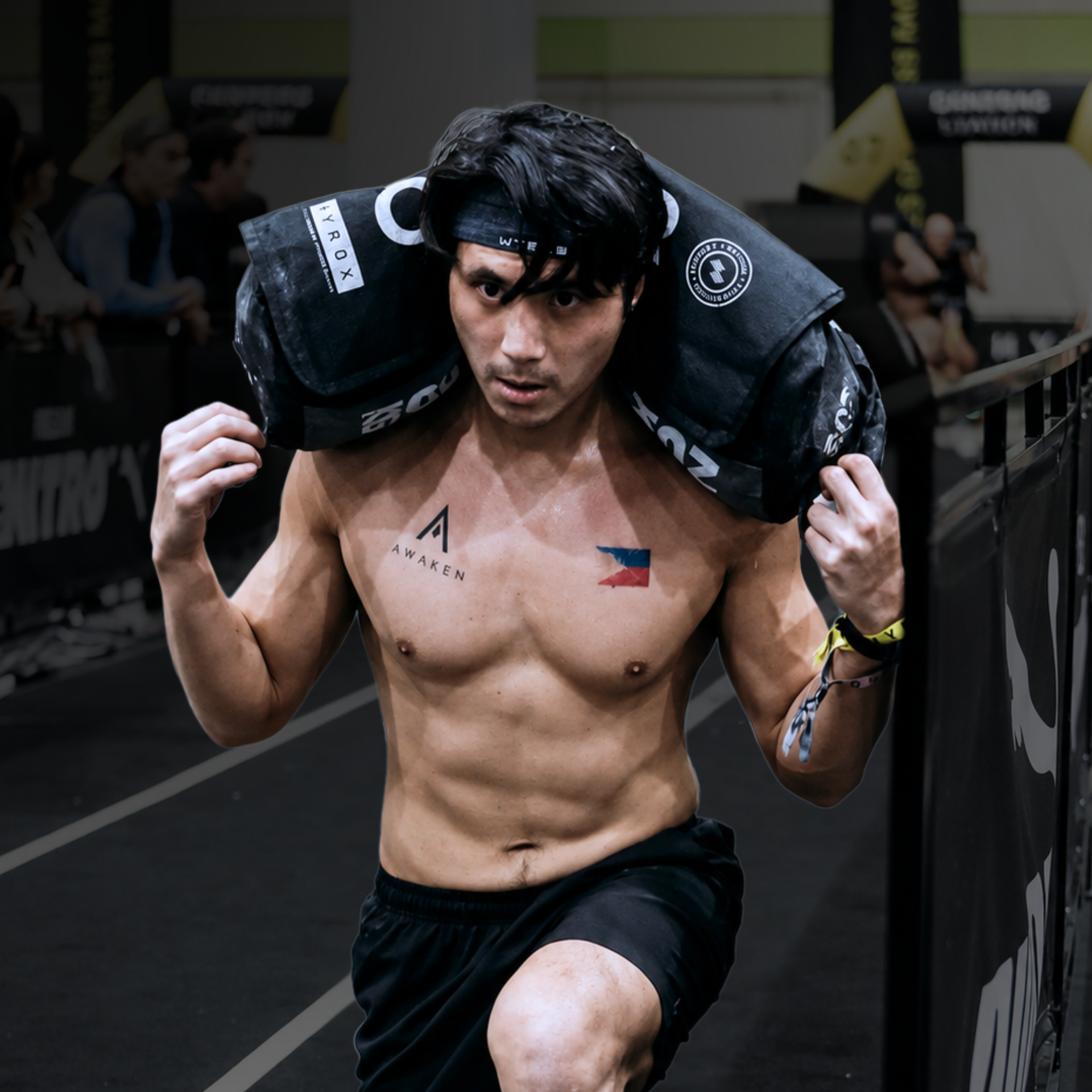 Boxer carrying black sandbags in a gym, moving forward with a focused expression.