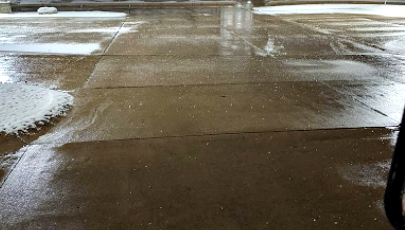 Wet, concrete floor with patches of white foam.