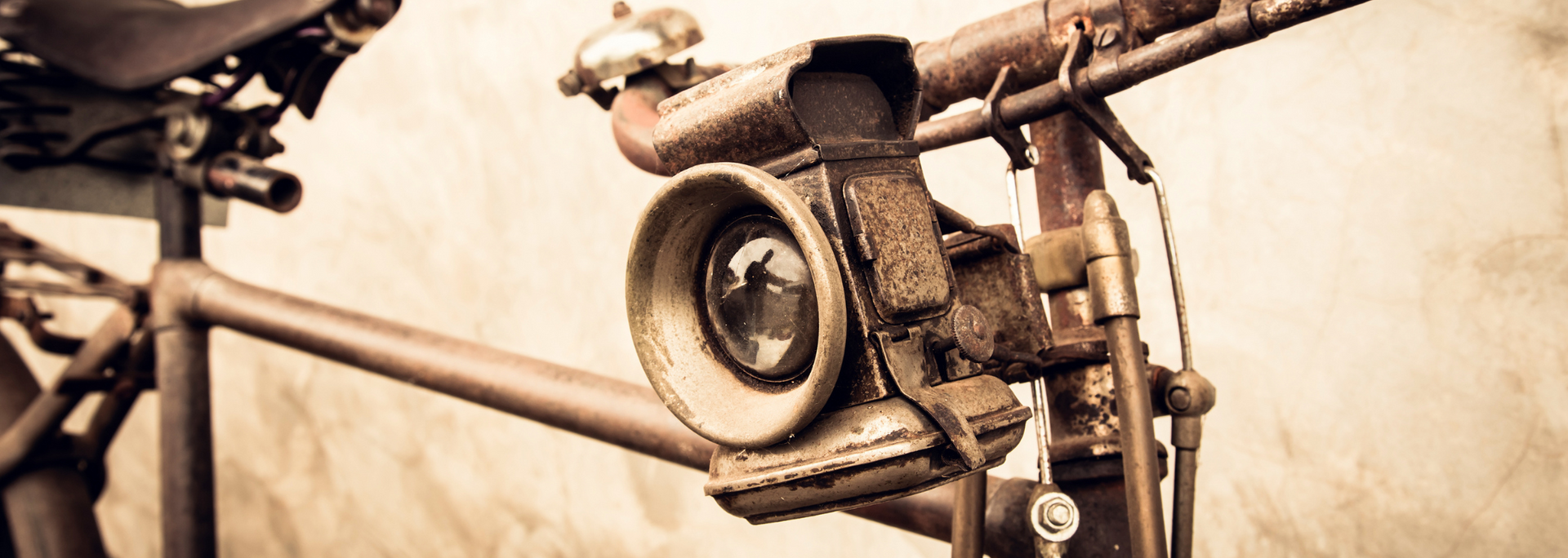Rusty vintage bicycle with a large, industrial-looking camera attached to the handlebars.
