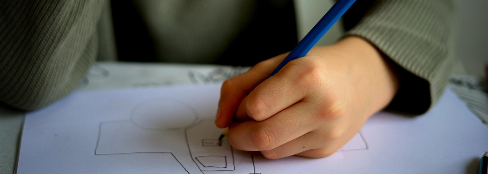 A hand drawing with a blue pencil on white paper. The person is wearing a gray blazer.