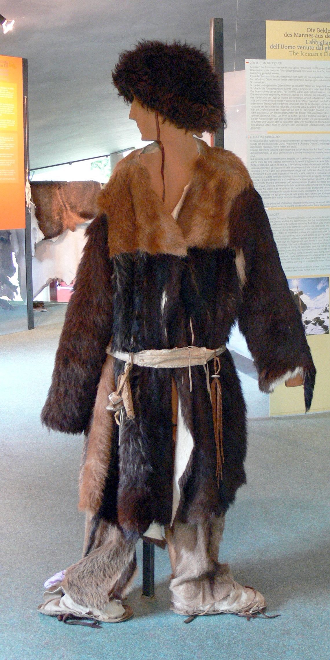 Mannequin in a fur outfit, standing in a museum.