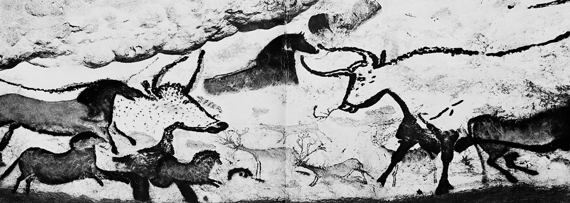 Cave painting depicting animals and a figure.