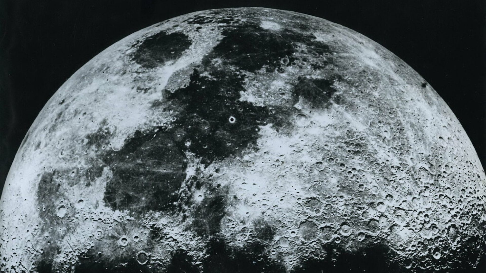 Crescent moon in black and white, showing craters and dark lava plains against a dark sky.