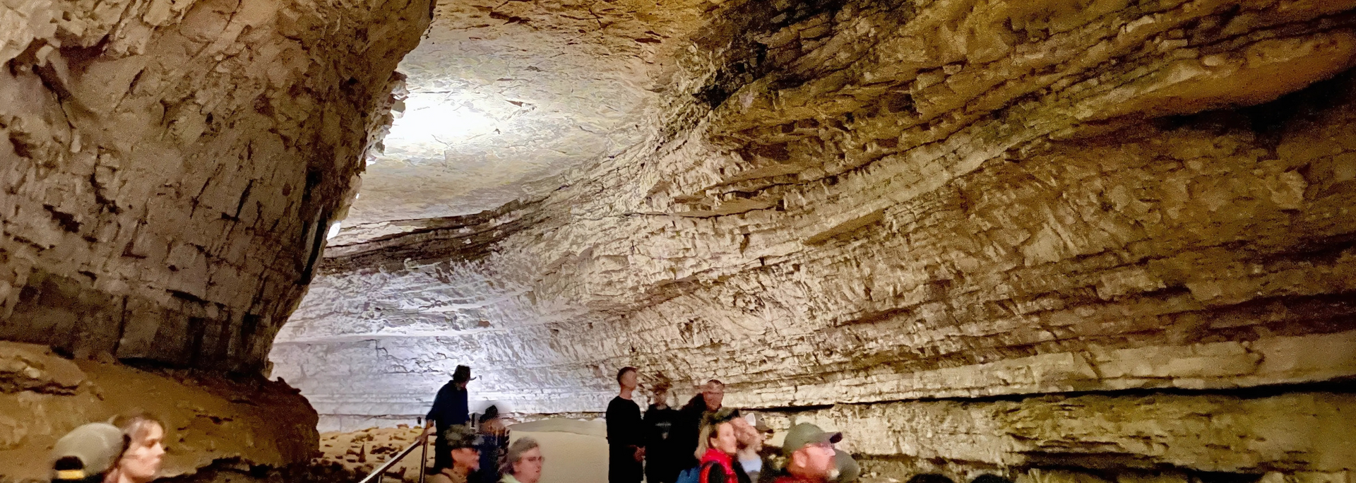 A group of people inside a cave with textured walls.