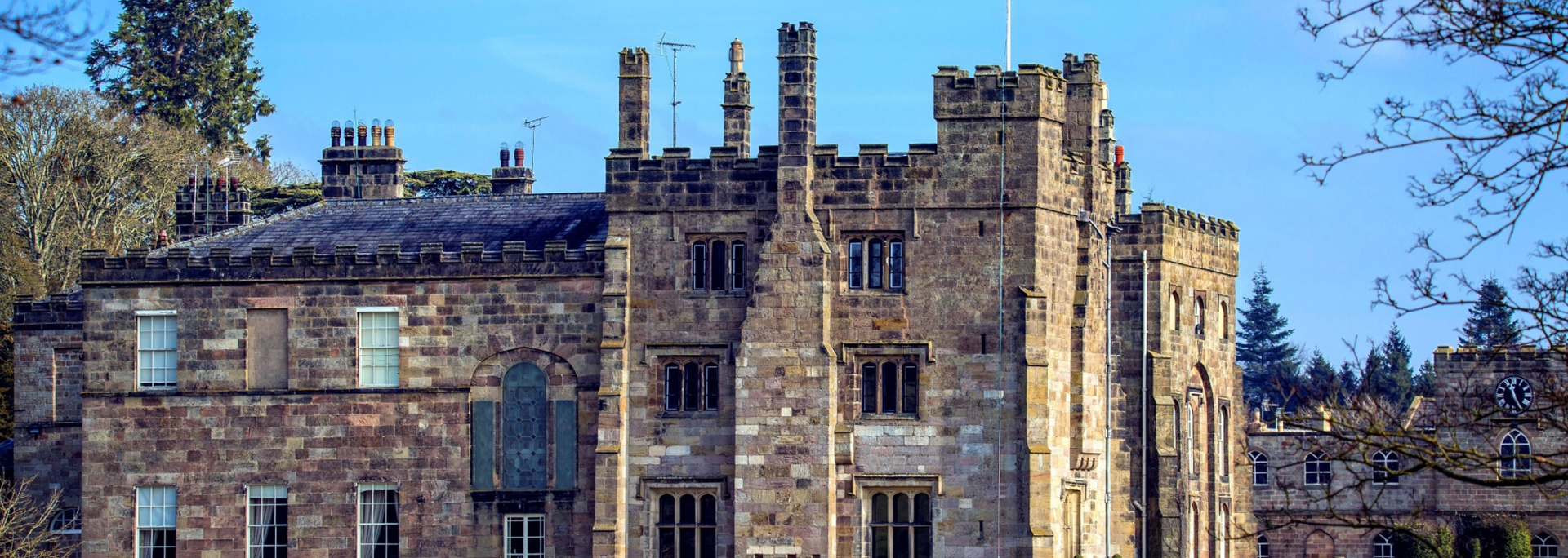 Stone castle with towers and windows, against a blue sky.