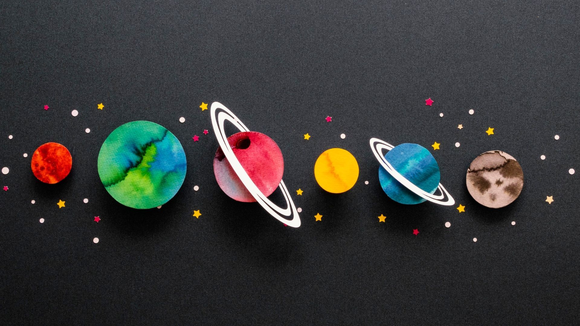Colorful handmade planets on a black background, with stars.